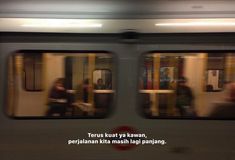 people are sitting on the subway train as it's moving through the city at night