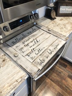 a kitchen counter with writing on it and a stove top oven in the back ground