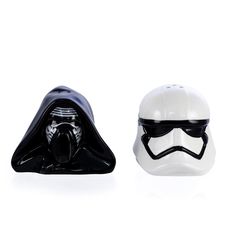 two star wars helmets sitting next to each other on a white surface, one is black and the other is white