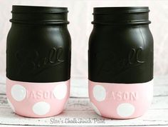 two black and pink mason jars with white polka dots on the bottom, one has a name painted on it