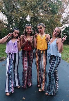 three girls are standing on a trampoline with their hands in the air and making peace signs