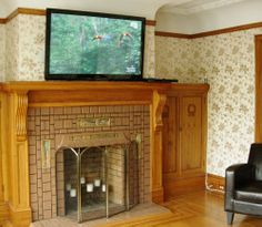 a living room with a fireplace and tv on top of it