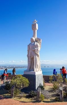 people are standing around in front of a statue