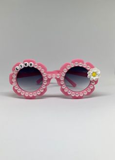 Adorable personalized flower shaped sunglasses for your little babes! These are custom made for you with variations of frame colors, charms, and personalized with your name or slogan. If you have a special request, please let me know and I will do my best to accommodate. Details-  💗Customize with letters in the personalization box. These come with black or gold letters on white beads. I can also make these non-personalized if you like, just let me know in the custom box. 💗Choose your charm- so Pink Sunglasses As A Gift, Adjustable Pink Sunglasses As Gift, Trendy Handmade Pink Sunglasses, Custom Name Pink Sunglasses With Adjustable Fit, Personalized Pink Sunglasses As A Gift, Pink Sunglasses With Custom Name And Adjustable Fit, Pink Personalized Sunglasses For Gift, Customizable Pink Sunglasses For The Beach, Personalized Playful Sunglasses For Party