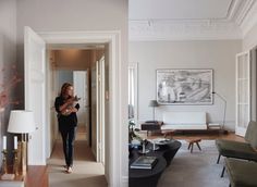 a woman standing in a living room next to a couch