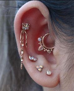 an ear with three different types of piercings on top of it and one is attached to