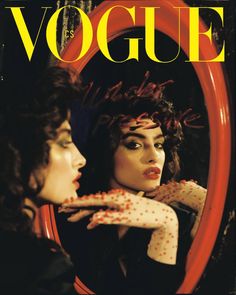 a magazine cover with two women looking at each other's faces in front of a mirror