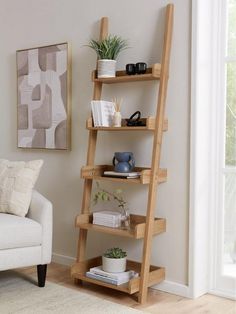 a living room with a white couch and a wooden ladder shelf