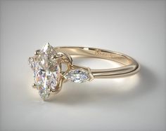 an oval cut diamond ring with two pear shaped diamonds on the band and side stones