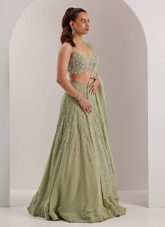 Embrace a look of sophistication with this beautifully designed Mint Green Embellished Organza Lehenga, perfect for making a statement at any celebration. Crafted from lightweight organza, the mint green lehenga features intricate crystal and cut dana embroidery, adding a touch of sparkle. Paired with a beautifully embroidered scoop neck blouse and a sheer dupatta that drapes gracefully. Ideal lehenga set for Mehndi, Sangeet, or as wedding guest attire. Composition : Lehenga, Blouse, Dupatta - Organza and Shantoon Care: Dry Clean Only and Vacuum Storage This product can be customized for sleeves, blouse length and neckline Delivery : 6-8 weeks as the product is hand crafted. Check Size Guide or choose MySize for free customisation (All Sizes above XL can be made at 15% additional cost) For