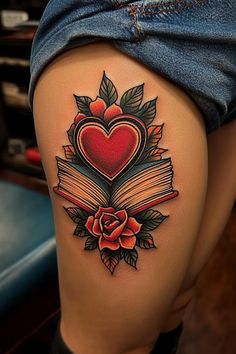 a woman's thigh with an open book and heart tattoo on it