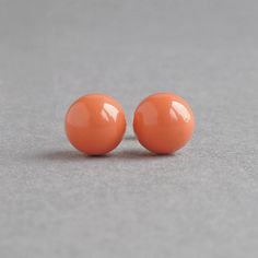 This simple pair of pumpkin stud earrings has been created using 8mm coral orange glass pearls. As each pair arrives individually gift wrapped in the black box pictured, these glossy studs would make the perfect keepsake/gift for bridesmaids. These salmon peach pearl studs are great for women who love colourful jewellery. All of the metal elements used are Sterling silver. Each pair of post earrings is fitted with a pair of butterfly backs to ensure your earrings stay in place. You jewellery wil Sugarfix By Baublebar Earrings Orange, Orange Bridesmaids, Studded Pumpkin, Chunky Stone Necklace, Floating Pearl Necklace, Chunky Pearl Necklace, Salmon Peach, Colourful Jewellery, Peach Jewelry