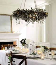 a dining room table is set with candles, plates and silverware for christmas dinner