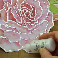 someone is painting a rose with acrylic paint on the paper and it's pink