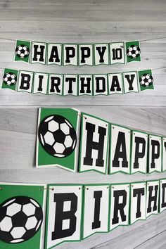 two banners with soccer balls and the words happy birthday are hanging on a wooden wall