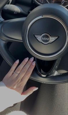 a woman's hand on the steering wheel of a car