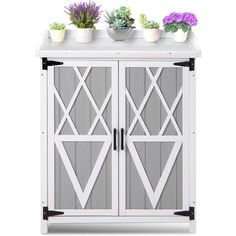 two potted plants sit on top of a white cabinet with grey doors and black handles