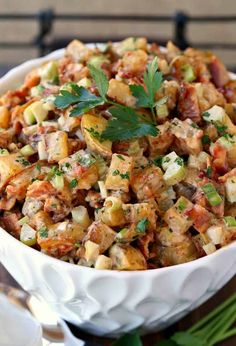 a white bowl filled with stuffing and garnished with parsley on the side