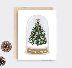 a card with a christmas tree under a glass dome on top of a white surface