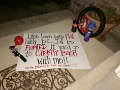 a sign that is sitting on the ground near a door mat with balloons and confetti