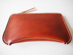 "Simple yet unique formed zipped pouch. Using two types/colours of vegetan leather. Has a inside pocket. Able to use as a cosmetic bag, clutch bag, wallet, travel wallet and more. - Made from 100% Vegetable tanned leather - Hand stitched with waxed thread - Edges are burnished to smooth sheen - YKK metal zipper - Comes with 100% cotton bag Approximate Dimensions: W 8\" x H 5\" x D 1.50'' W 20cm x H 13cm x D 4cm Zipper length: 7\" 18cm Personalisation (optional) - Complimentary personalisation is Leather Clutch Pouch With Zipper Pocket, Brown Clutch Pouch With Zipper, Brown Clutch Pouch With Zipper Pocket, Brown Leather Zipper Pouch, Leather Coin Purse With Zipper, Leather Clutch Pouch With Coin Pocket, Leather Wallets With Zipper Pouch, Leather Wallet With Zipper Pocket, Brown Pouch Clutch With Coin Pocket