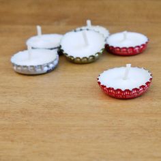 four candles are sitting on a wooden table