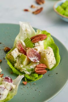 lettuce and fruit salad on a plate with pecans in the back ground