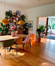 a dining room with wooden floors and lots of plants