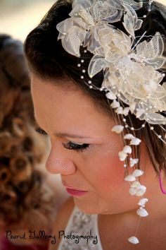 a woman wearing a bridal headpiece with flowers on it