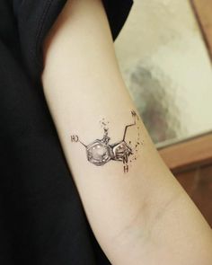 a woman's arm with a tattoo on it that has an image of a flying saucer