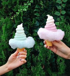 two people holding ice cream cones in their hands