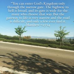 the road is empty and there are trees in the distance with a bible verse written on it