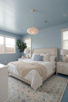 a bedroom with blue walls and white bedding in the center, along with an area rug on the floor