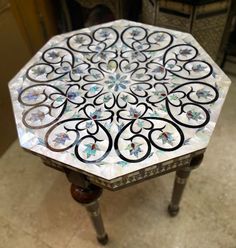 a marble table with an intricate design on it's top is shown in this image