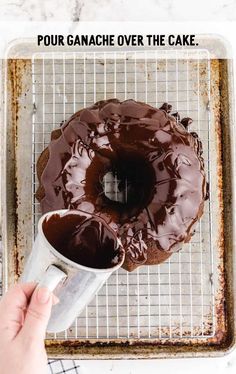 a chocolate cake on a cooling rack with the words pour ganache over the cake