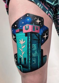 a woman's thigh with an image of a building and stars painted on it