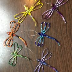 four dragonflys made out of string on a table