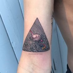 a tattoo on the arm of a man with a triangle and an eye in it