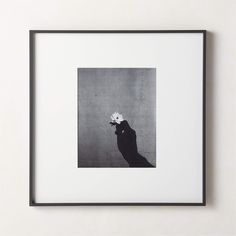 a black and white photo with a person holding a flower in it's hand