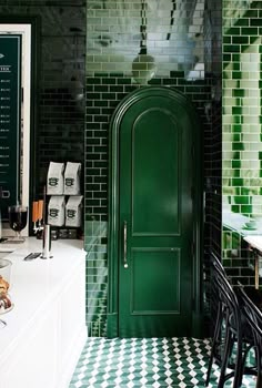 a green door in the middle of a kitchen with black and white checkered flooring