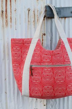 a red and white bag hanging on a metal wall