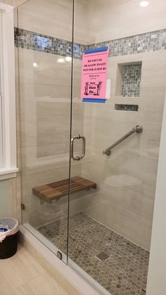 a glass shower door with a sign on it