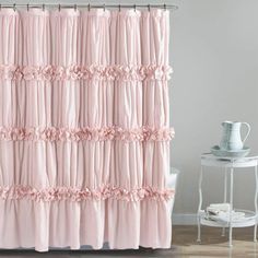 a pink shower curtain with ruffles on the top and bottom, in a bathroom