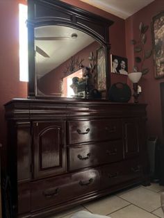 a dresser with a large mirror on top of it