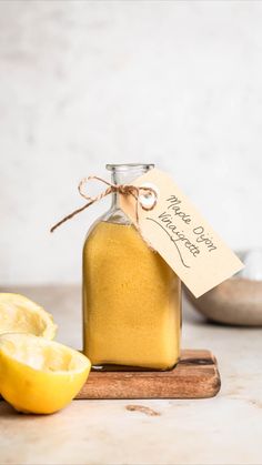 a glass jar filled with liquid next to sliced lemons