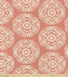 an orange and white pattern on fabric with a ruler in the foreground, it is very