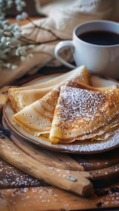 some powdered sugar is sitting on a plate next to a cup of coffee