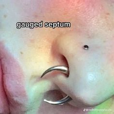 a close up of a person's nose with an ear piercing on top of it