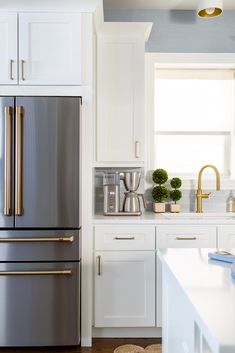 a kitchen with stainless steel appliances and white cabinets