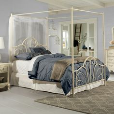 a white bed sitting in a bedroom next to a dresser